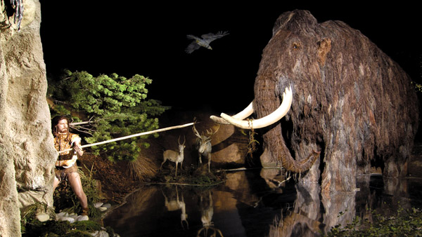 fotografie modelu mamuta, na ktereho utoci praveky clovek