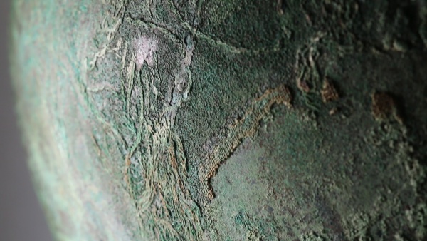 Fotografie. Detail vědra se zbytky textilních vláken. Zdroj: Národní muzeum