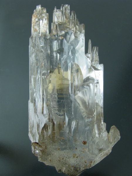 Fotografie. Velký, čirý krystal topazu vysoký 8,5 cm pocházející z lokality Nerčinsk (Rusko). Jeho povrch je přirozeně naleptaný přírodními roztoky. V expozici „Svět nerostů“ se návštěvník setká s množstvím unikátních ukázek minerálů z celého světa. Exemplář ze sbírek mineralogicko-petrologického oddělení NM.