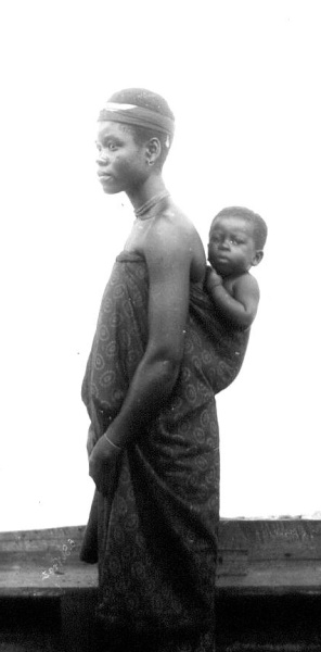 Fotografie. Matka s dítětem v látkovém úvazu na zádech. Ghana (Zlaté pobřeží), 1885-1888. Zdroj: Národní muzeum