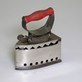 Další hračkou pro malé hospodyňky je i tato napodobenina žehličky na dřevěné uhlí z 20.–30. let 20. století