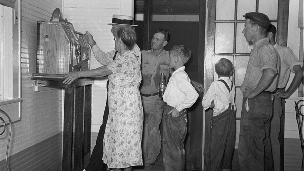 Lidé sledují hru na automatu, Pilottown, Louisiana, rok 1938. (zdroj: Federální vláda Spojených států amerických)