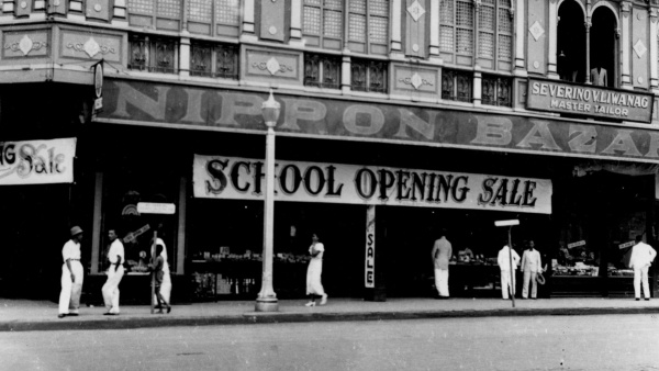 Fotografie. Dřevěná budova bazaru Nippon s poutačem „School Openig Sale“, Manila, 1934. Zdroj: Národní muzeum